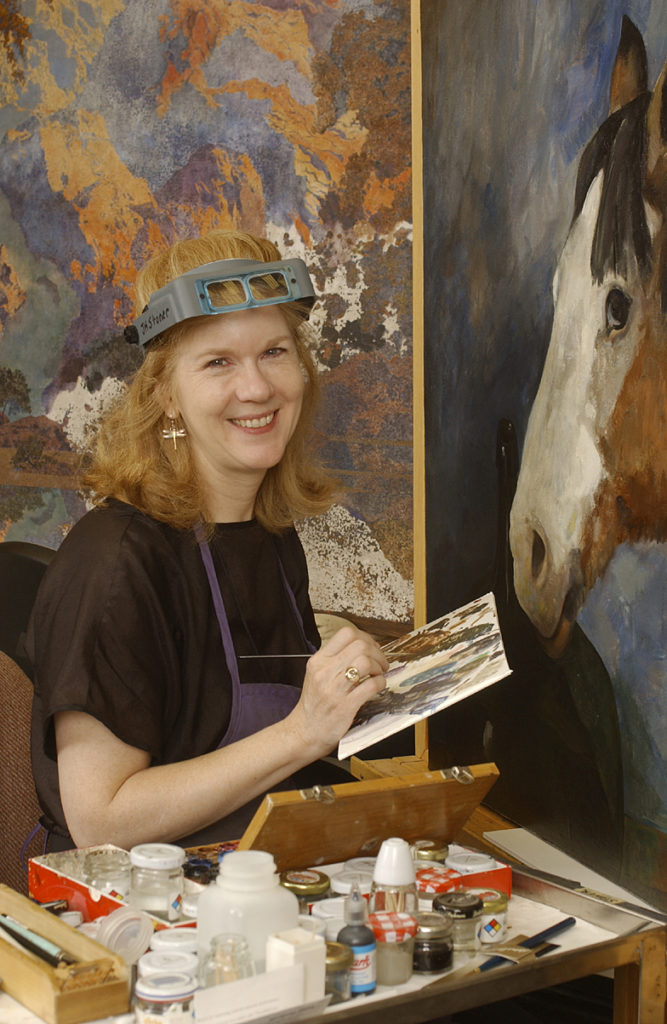 U of D Prof. Joyce Hill-Stoner, art conservation, in her studio at Winterthur Museum. behind her is a Maxfield Parrish (L) and a Jaimie Wyeth (Rt)
